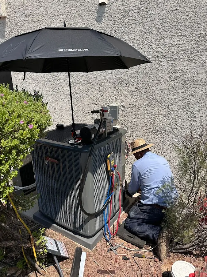HVAC technician performing outdoor AC maintenance in Zanesville